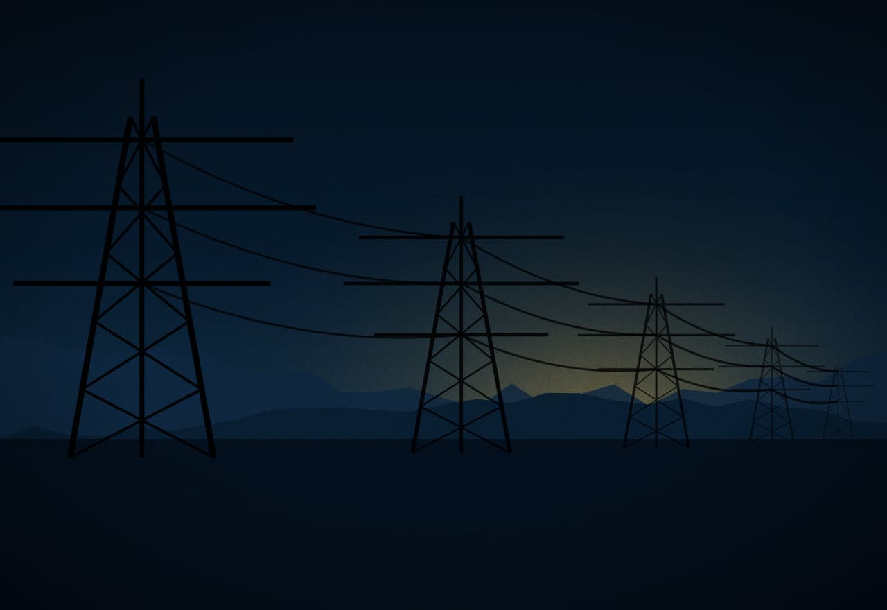 High-voltage transmission towers carrying conductors across a valley at dusk.